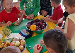 Dzieci kroją owoce.